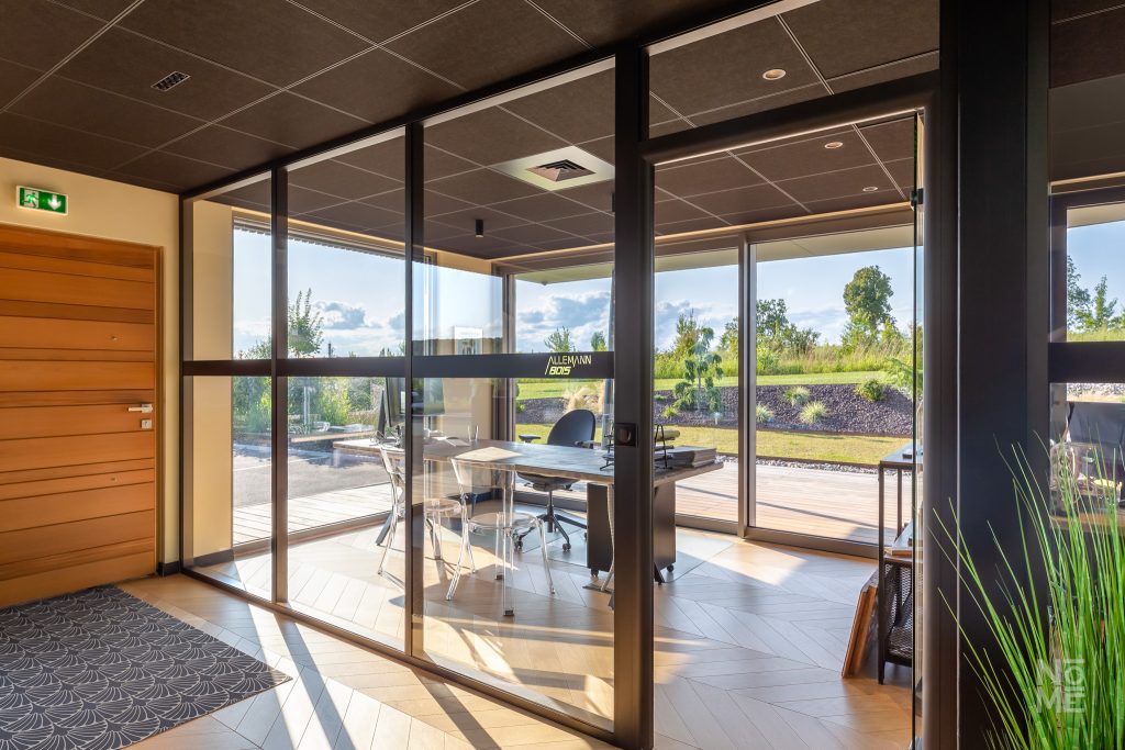Espace de travail lumineux avec grandes baies vitrées conçu par Atelier Nōmé