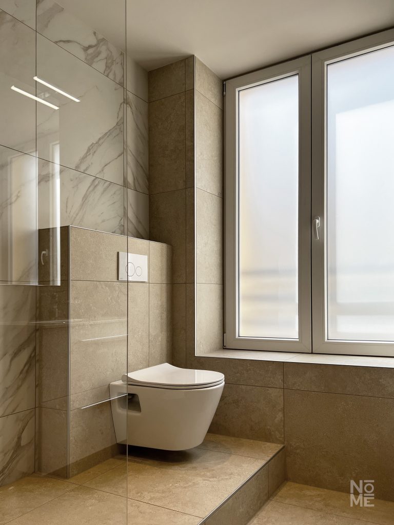 Salle de bain avec baignoire et fenêtre dans un appartement rénové en Alsace