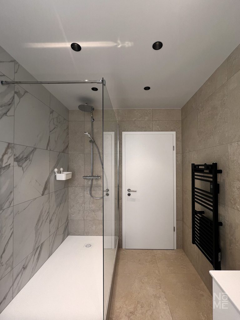 Salle de bain en marbre avec douche à l’italienne dans un appartement rénové en Alsace